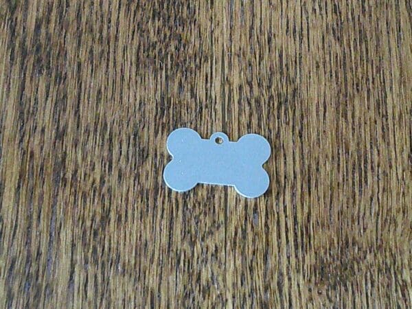 A bone shaped tag is laying on the floor.