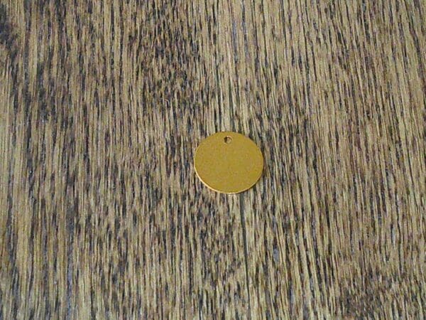 A gold disc sitting on top of a wooden table.