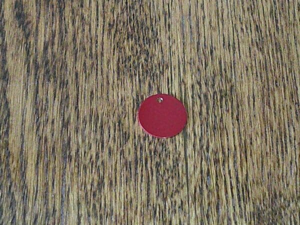 A red circle on top of a wooden table.