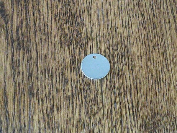 A wooden table with a blue round tag on it.