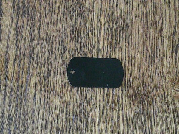 A dog tag is laying on the floor.