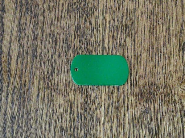 A green tag sitting on top of a wooden table.