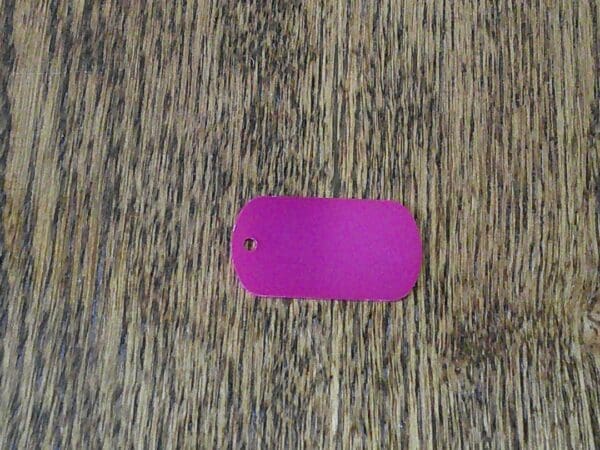 A purple tag sitting on top of a wooden floor.