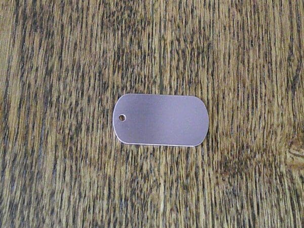 A dog tag sitting on top of a wooden floor.